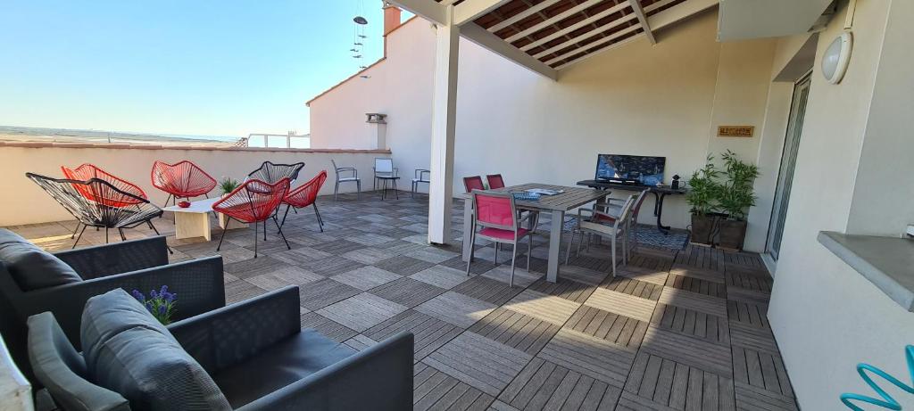un patio avec une table et des chaises sur un balcon dans l'établissement vue mer et garrigue, à Saint Pierre La Mer