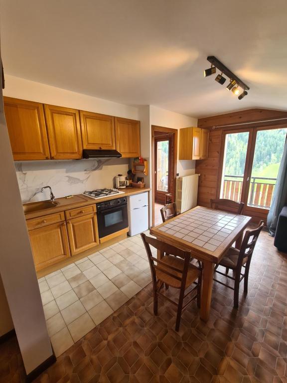Una cocina con una mesa de madera y una mesa y sillas. en La Loulettaz, en Le Grand-Bornand