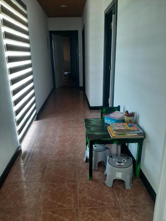 a room with a green table and a hallway at Casa vicente in Santa Cruz das Flores