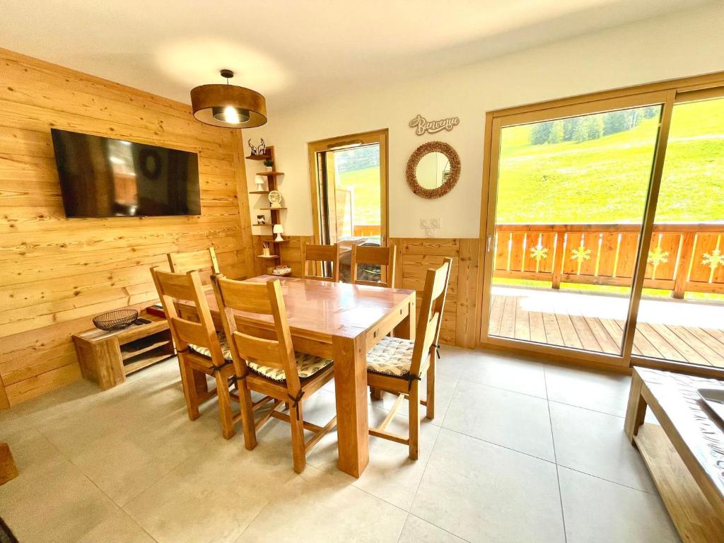 une salle à manger avec une table et des chaises en bois dans l'établissement Appartement neuf sur les pistes avec parking et wifi - FR-1-505-190, à Notre-Dame-de-Bellecombe
