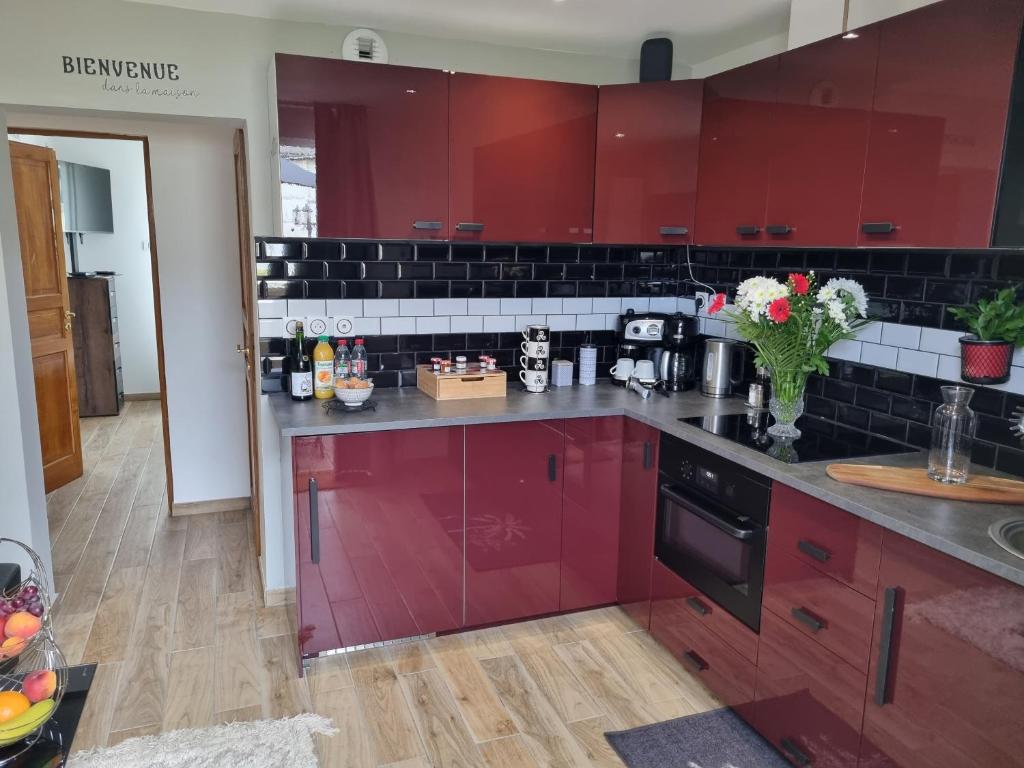 une cuisine avec des armoires rouges et un comptoir dans l'établissement Les Appart du Sillon, à Pleubian