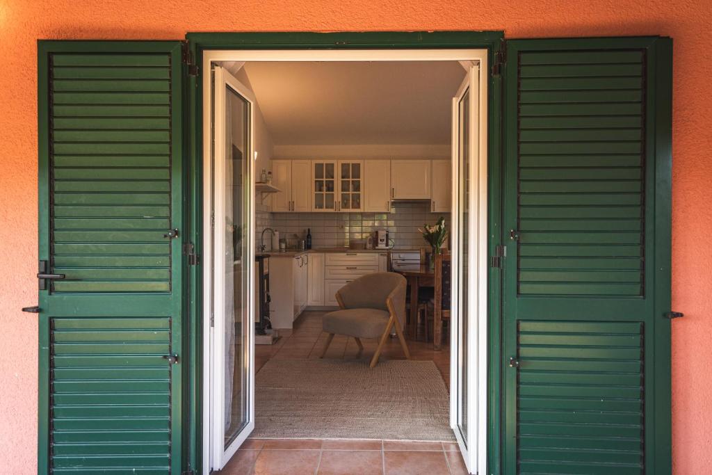 una porta aperta per una cucina con persiane verdi di Holiday Home “Vuko” a Trilj