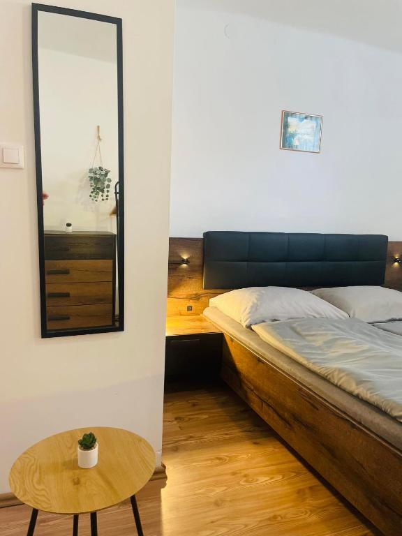 a bedroom with a bed and a table and a mirror at Bükk-Völgye Vendégház in Bogács