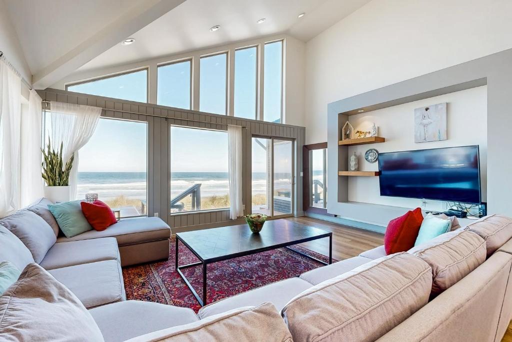 a living room with a large couch and a tv at Pacific Dream in Neskowin