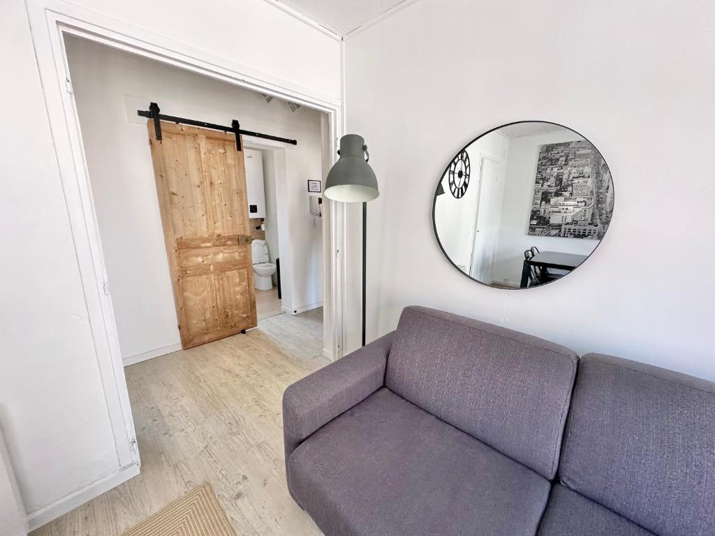 un salon avec un canapé et un miroir dans l'établissement Calme - Balcon - 2 à 4 pers - WIFI - plage à 100m, à Berck-sur-Mer