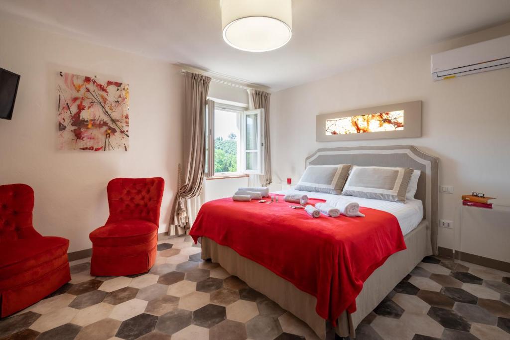 una camera con un letto rosso e una sedia rossa di Vinci - Idea Resort - Tuscany a Vinci