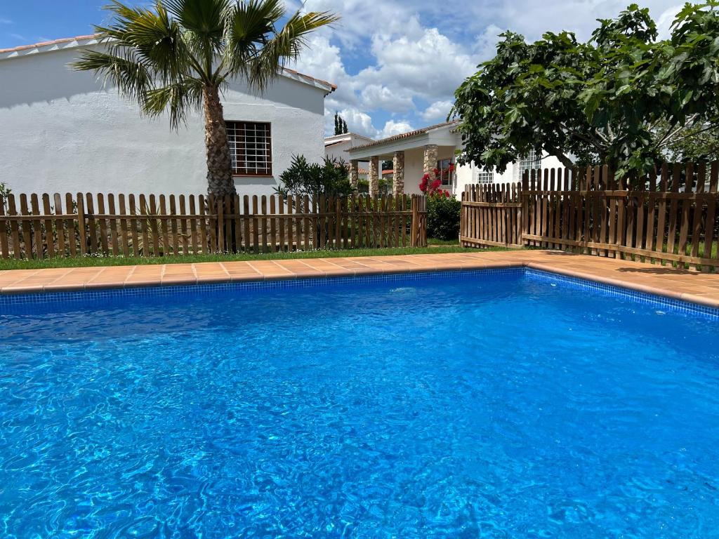 a large blue swimming pool in front of a house at Villa Montserrat 3, Terrace & Pool in Sant Martí d’Empúries