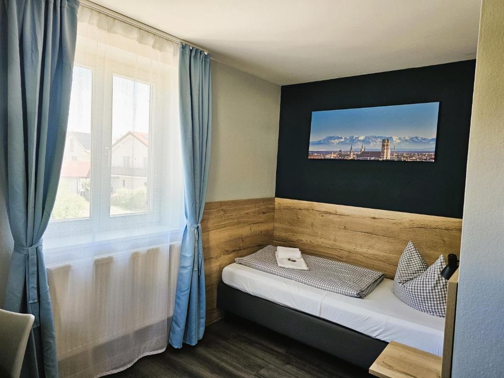 een klein bed in een kamer met een raam bij Novitel Pension Pliening - München Messe in Pliening