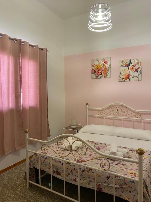 een slaapkamer met een wit bed en roze gordijnen bij Casa Carolina in Collepasso