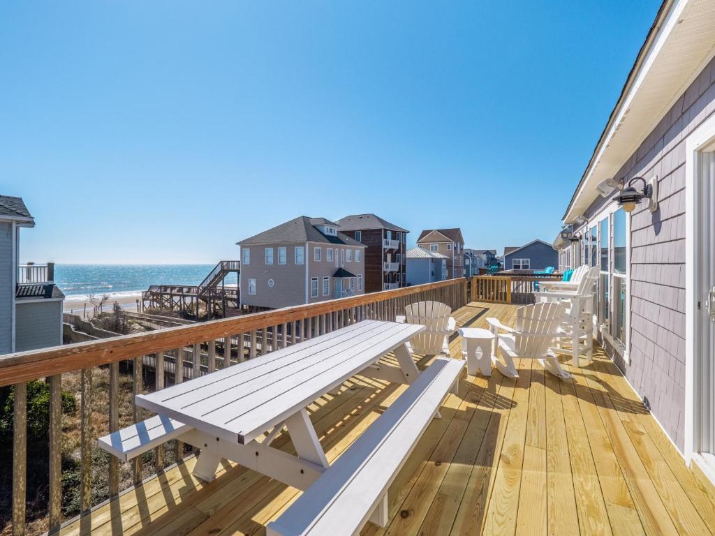 a deck with a picnic bench and the beach at LegaSea in North Topsail Beach