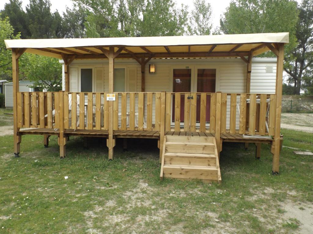 un gazebo en bois avec un porche et une terrasse dans l'établissement Mobil Home au calme Camping 4 Cadenet, à Cadenet