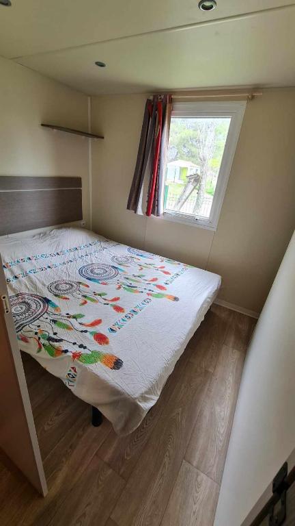 un lit dans une petite pièce avec une fenêtre dans l'établissement Mobil Home au calme Camping 4 Cadenet, à Cadenet