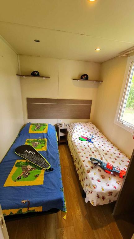 - une chambre avec un lit et une planche de surf dans l'établissement Mobil Home au calme Camping 4 Cadenet, à Cadenet