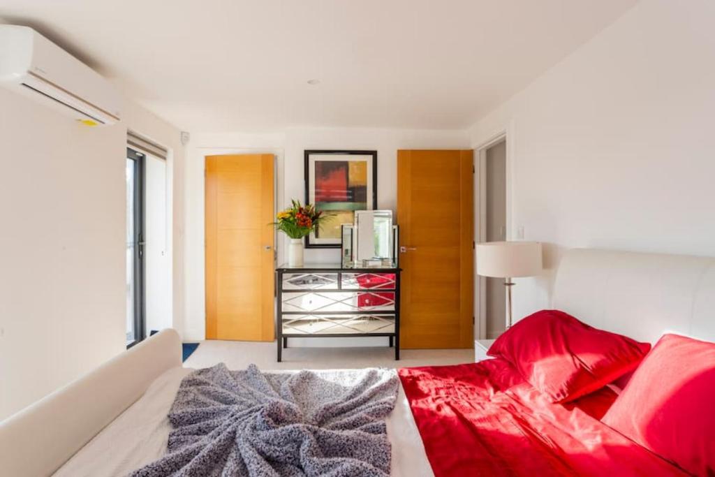 een slaapkamer met een bed met een rode deken bij The Retreat, Sauna & Hot Tub, Charming & Cosy Gem in Blandford Forum