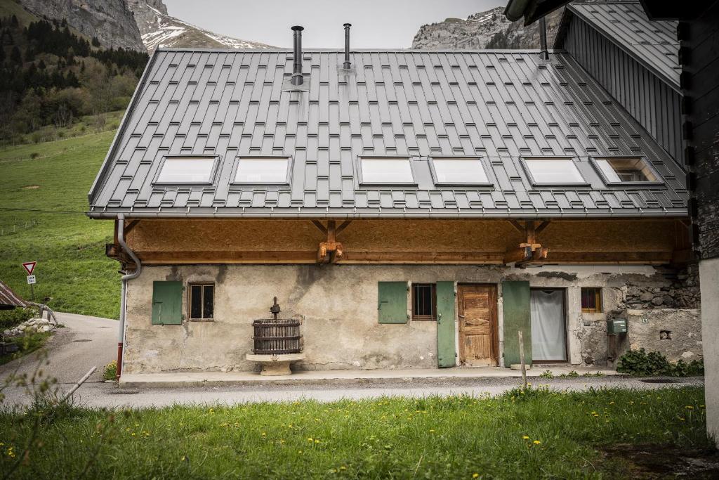 une vieille maison avec un toit gris et des portes vertes dans l'établissement Venez Chez Vous Mountain View, à Montmin