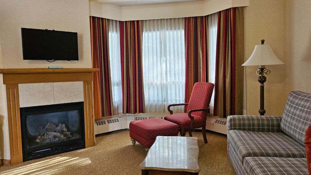 a living room with a couch and a fire place at Lake Louise Inn in Lake Louise