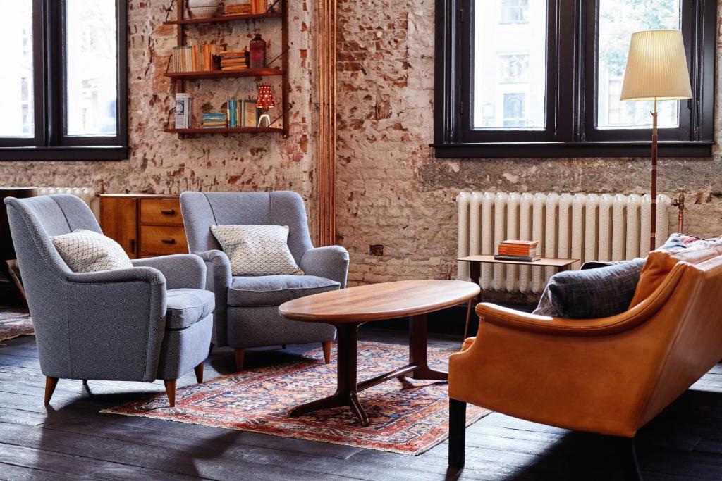 a living room with chairs and a table at The Hoxton, Amsterdam in Amsterdam
