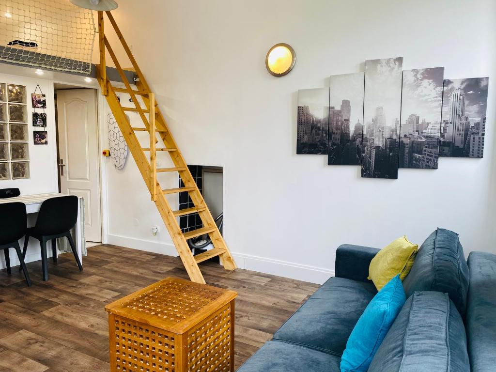 un salon avec un canapé bleu et une échelle dans l'établissement Studio Saint Denis, à Lagny-sur-Marne