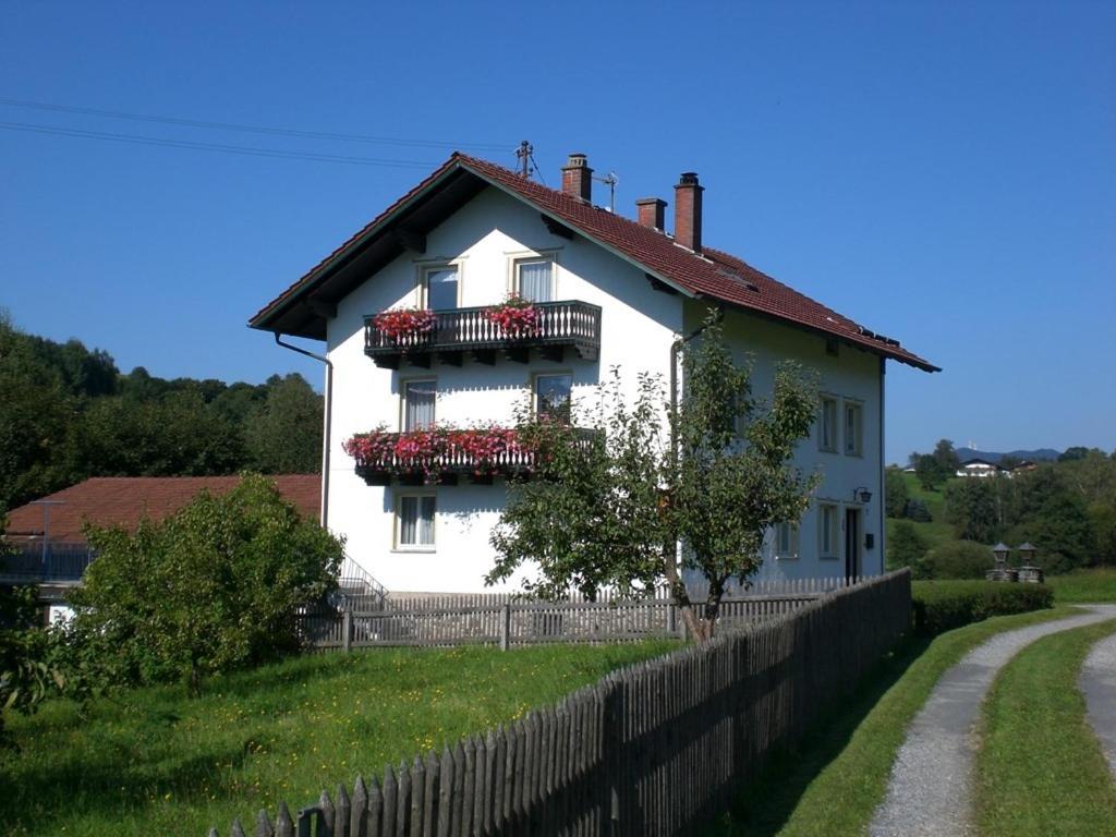 ein weißes Haus mit roten Blumen auf den Balkonen in der Unterkunft Reindl Peter in Lam