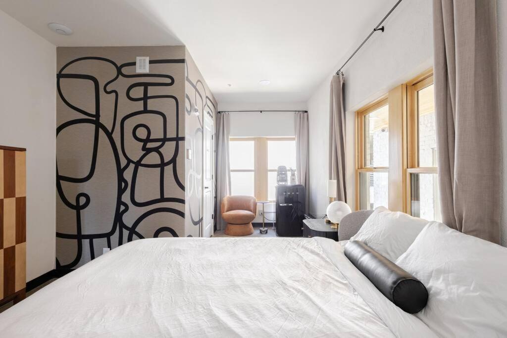 a bedroom with a large white bed with a mural on the wall at Walk to Bathhouses, Historic DTWN Building, Room # 302 in Hot Springs