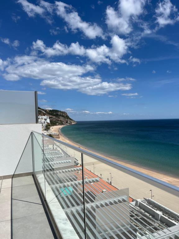 une vue sur la plage depuis le balcon d'un immeuble dans l'établissement Sesimbra Blue Paradise, à Sesimbra