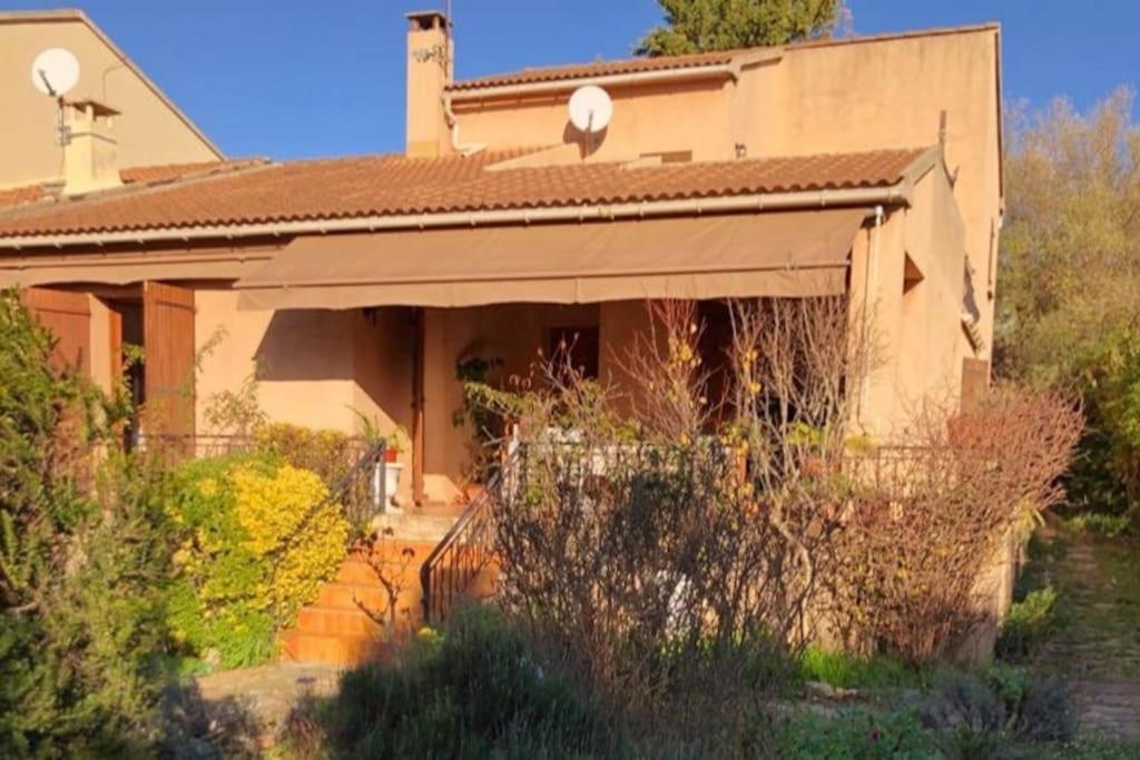 a house with an awning on the front of it at Villa avec grand jardin au centre de St Florent in Saint-Florent