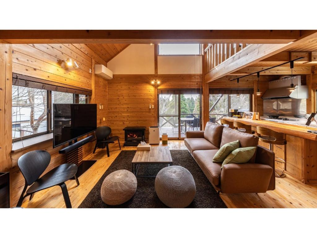 a living room with a couch and a tv at Kurokawa Mori No Kiki - Vacation STAY 14693v in Aso