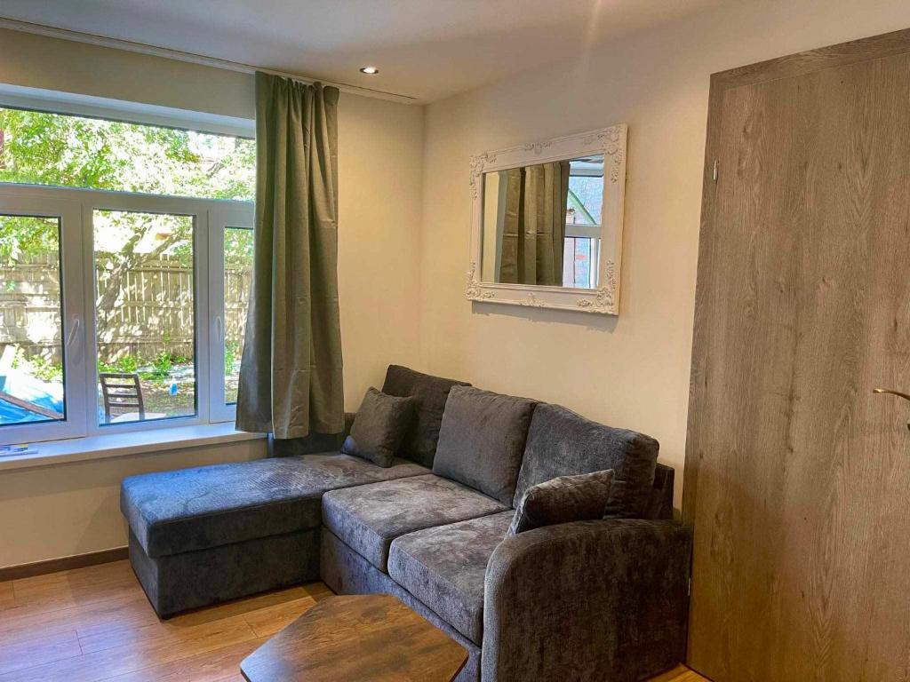a living room with a couch and two windows at City apartment in Pärnu