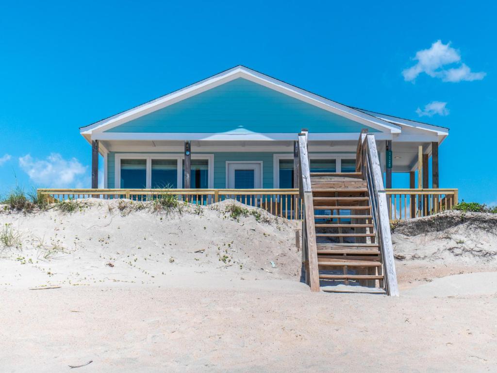 a blue house on the beach with a wooden porch at Lungomare in Surf City