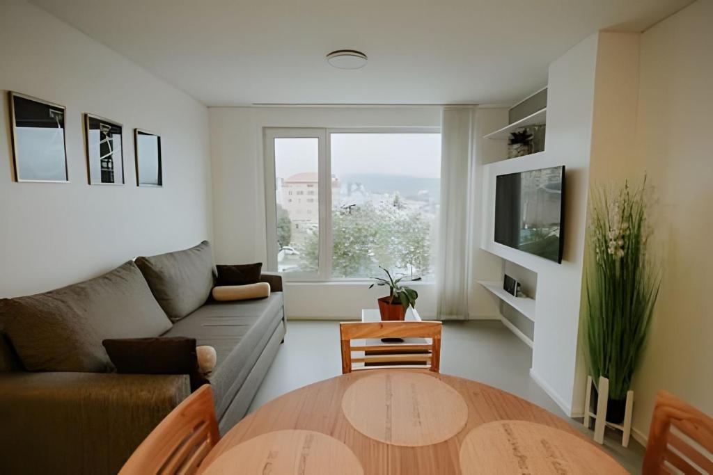ein Wohnzimmer mit einem Sofa und einem Tisch in der Unterkunft Aunaisin- Austral - 306 - Vista increible in Ushuaia