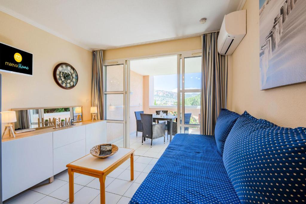 - une chambre avec un grand lit bleu et une table dans l'établissement Résidence le Hameau de Cap Esterel - maeva Home - Studio 4 personnes - Sélection MAE-9284, à Saint-Raphaël