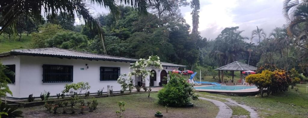 uma casa e uma piscina num quintal em Centro Vacacional Campestre La Sabrina em Villeta