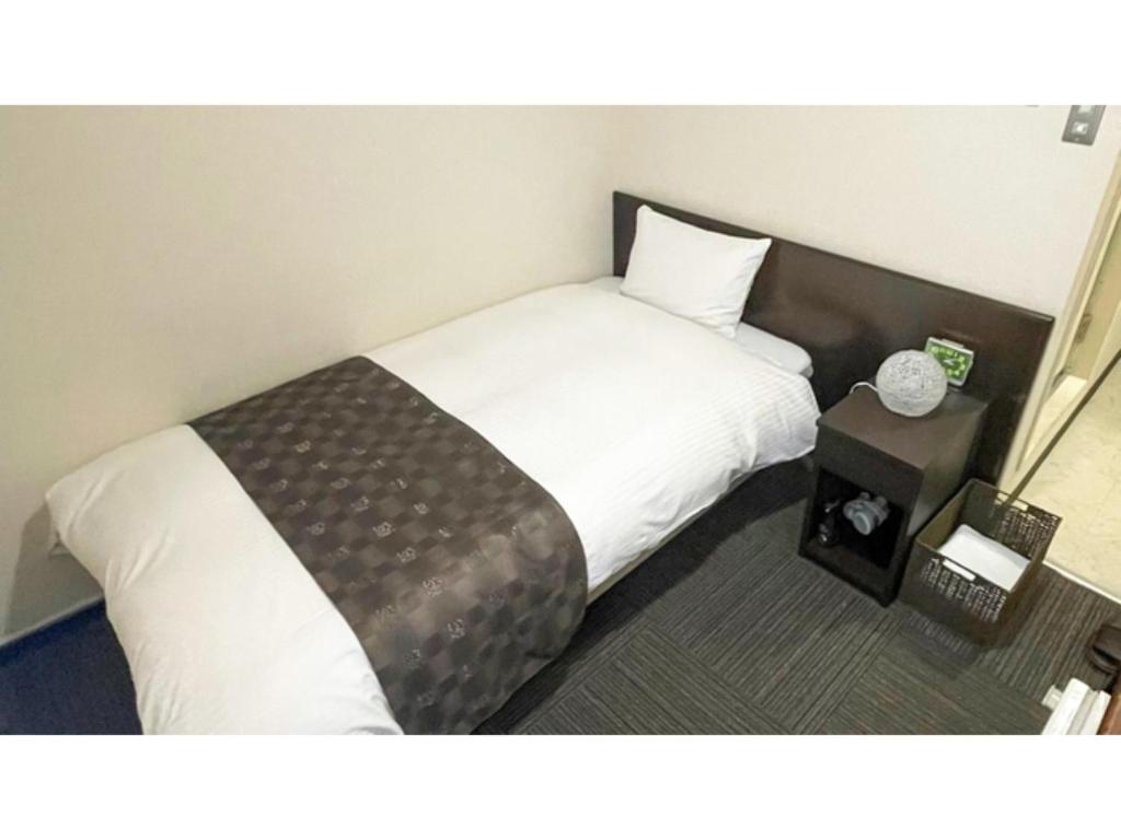 a hotel room with a bed and a side table at Takatsuki W&M Hotel - Vacation STAY 48509v in Takatuki