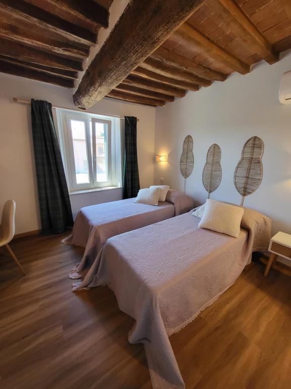 a bedroom with two beds and a large window at CasAlbina in Mezzana