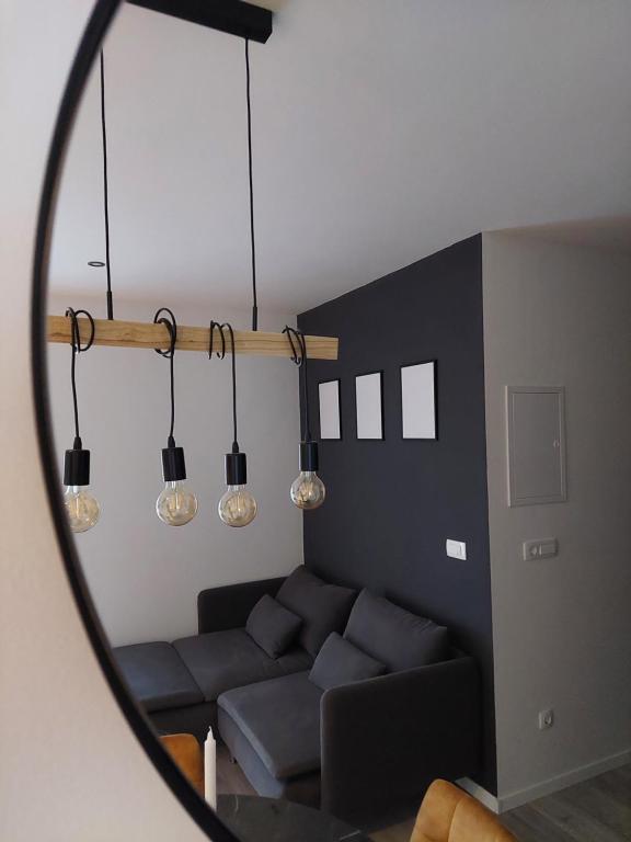 a living room with a blue couch and lights at Apartment Paola - Šibenik in Šibenik