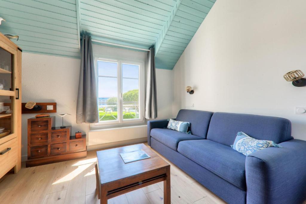 un salon avec un canapé bleu et une fenêtre dans l'établissement Résidence Port du Crouesty - maeva Home - Appartement 4 pièces 7 personnes - Confort MAE-0701, à Arzon