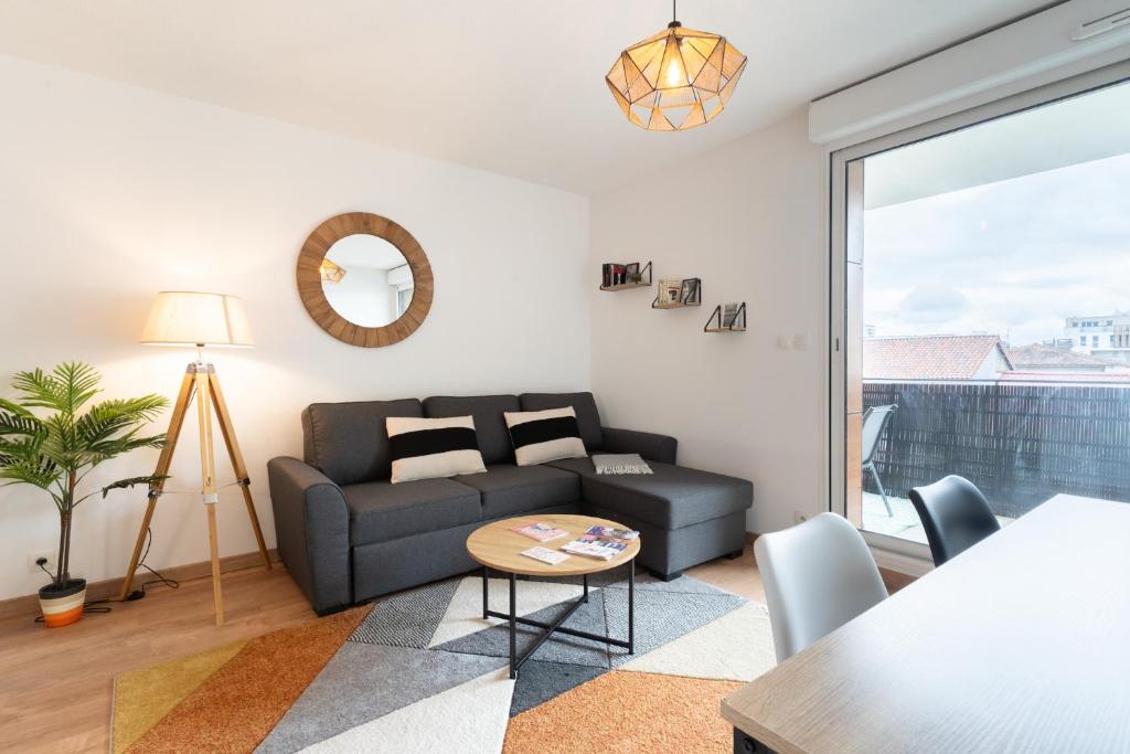un salon avec un canapé et une table dans l'établissement Le Rubens - Appartement 2 chambres - 6 personnes - Parking - Métro, à Toulouse