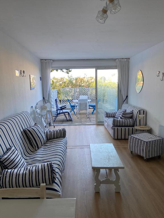 un salon avec deux canapés et une table dans l'établissement Studio Le Grau du Roi - proche de la mer, au Grau-du-Roi