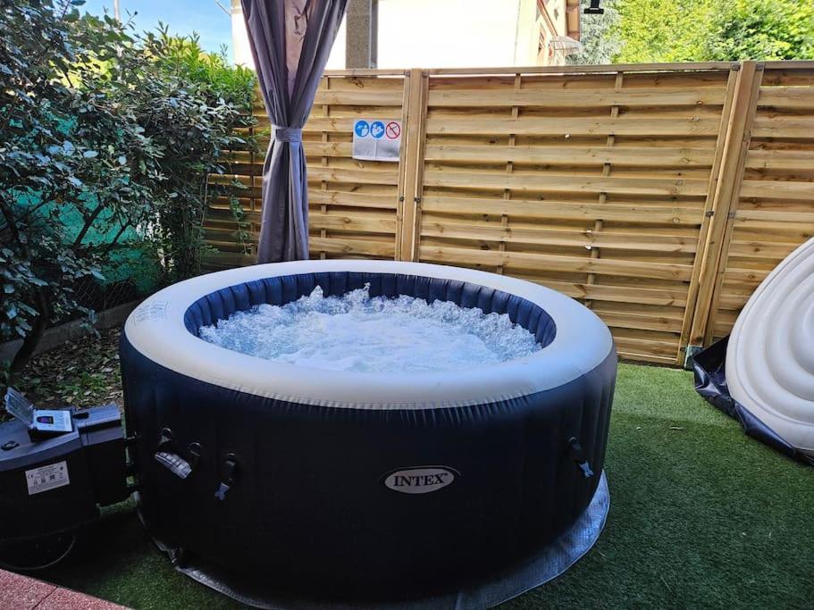 un bain à remous installé sur l'herbe dans une cour dans l'établissement Appartment Garden Plazza jacuzzi privé, à Toulouse