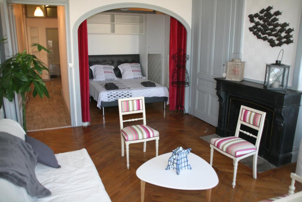 sala de estar con cama, sillas y chimenea en Chez Mo, en Lyon