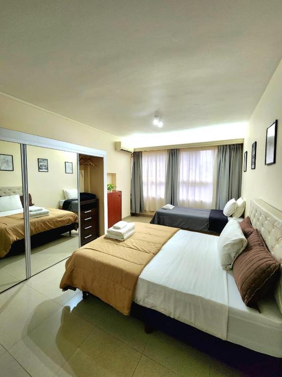 ブエノスアイレスにあるCéntrico departamento porteñoの広いベッドルーム(ベッド2台、鏡付)