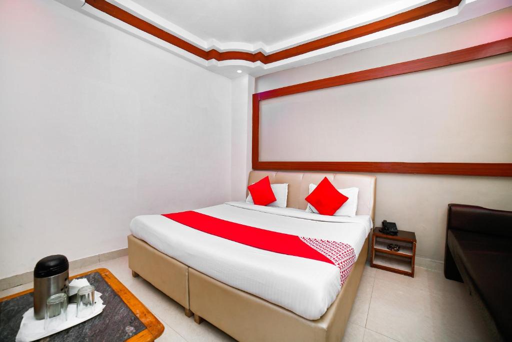 sypialnia z dużym łóżkiem z czerwonymi poduszkami w obiekcie OYO Rama Utsav w mieście Gwalijar