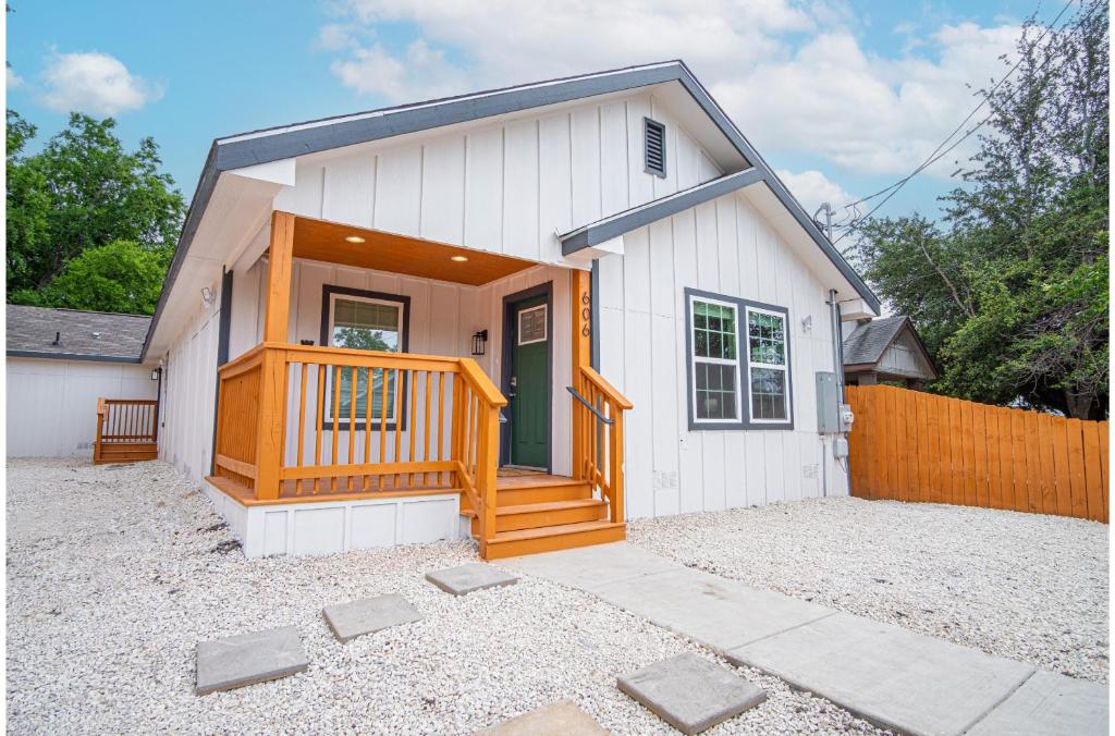 a small white house with a wooden porch at Spacious Delightful 4 BR 3 BA Close to Downtown in San Antonio
