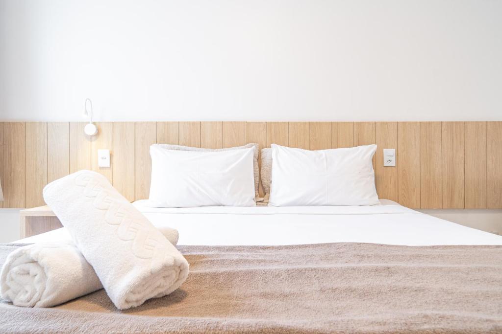 1 dormitorio con 1 cama con toallas en Pousada Areia do Forte, en Cabo Frío