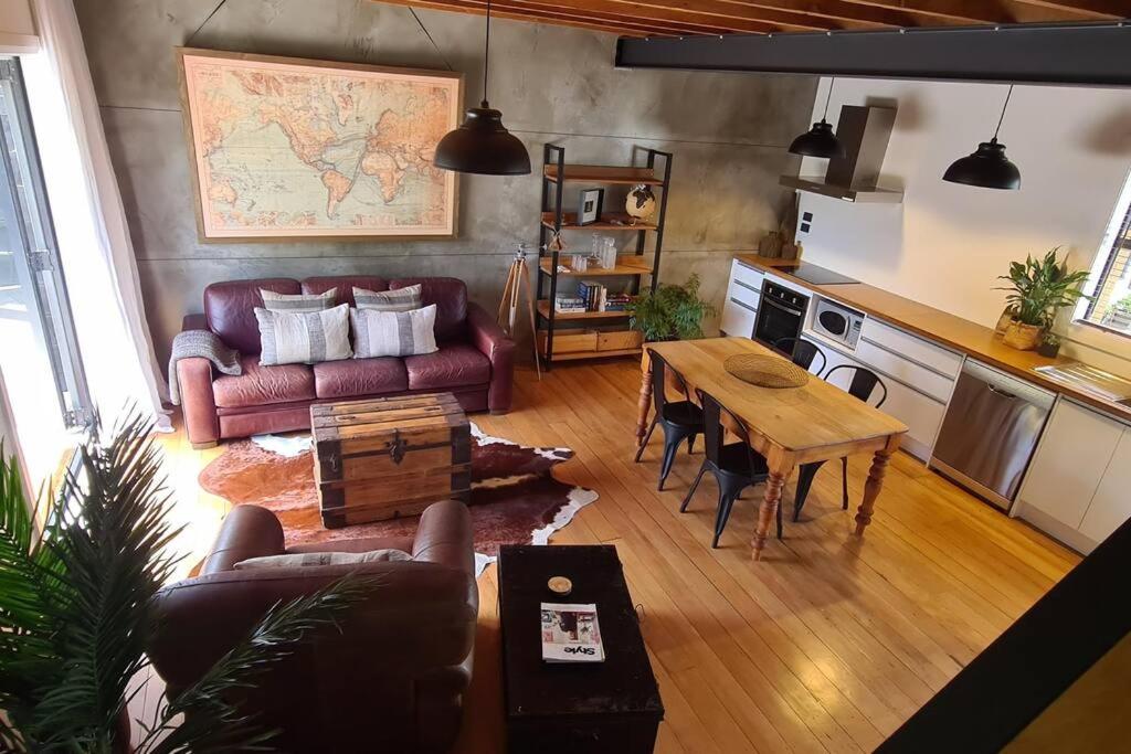 a living room with a couch and a table at Apartment 4 - Haddin Court - Chic NY Loft Style in Blenheim