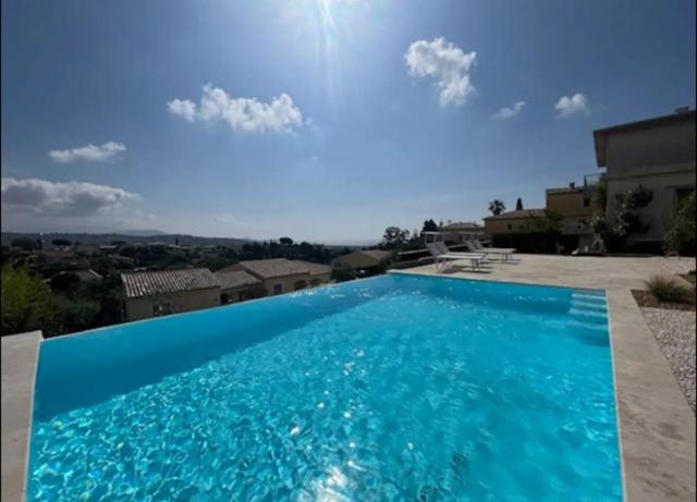 a large blue swimming pool on top of a house at DOMAINE LOU BEL AZUR - Elégant in Saint-Laurent-du-Var