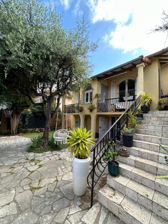une maison avec des escaliers et des plantes en pot dans l'établissement T2 RDJ sur la Côte d'Azur tout confort, à Cagnes-sur-Mer