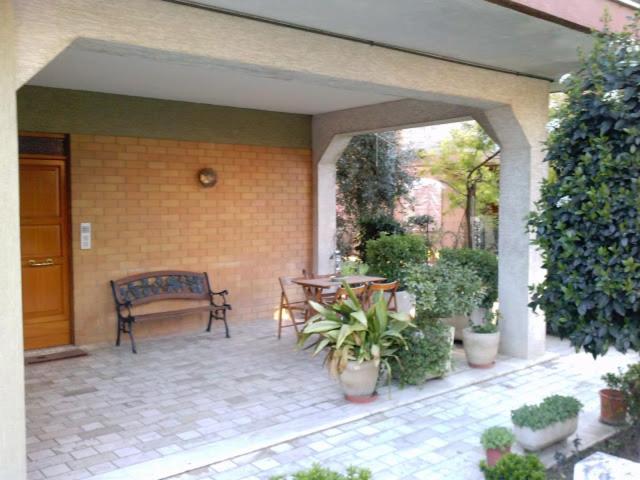a patio with a bench and a table with plants at Casa Vacanze Gabry in Porto San Giorgio