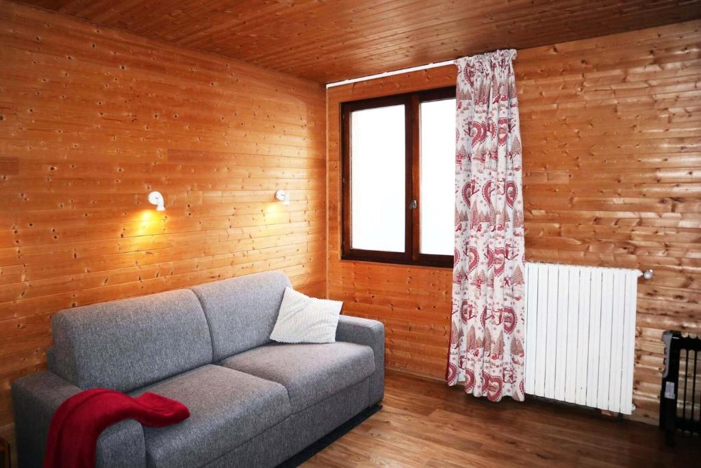 un salon avec un canapé et une fenêtre dans l'établissement Residence Le 1650 - Studio pour 2 personnes cœur de station des Orres 1650 MAE-5811, aux Orres