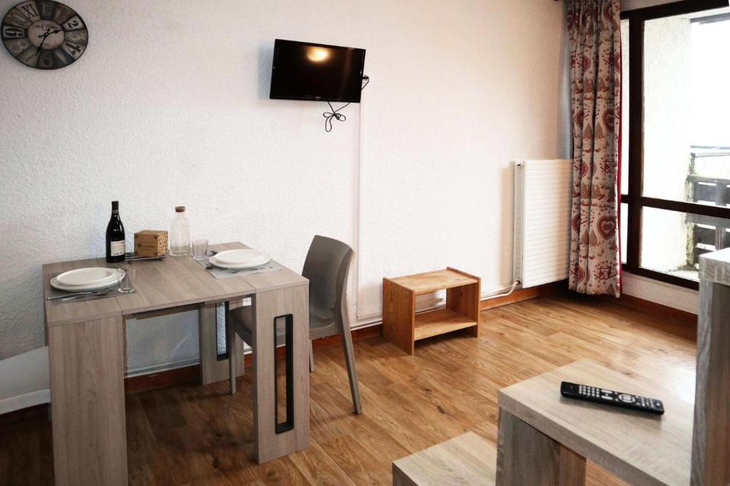 une salle à manger avec une table et une télévision murale dans l'établissement Residence Le 1650 - Studio pour 2 personnes cœur de station des Orres 1650 MAE-5831, aux Orres